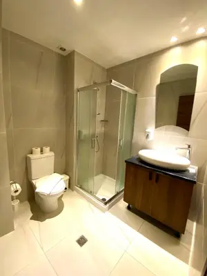 a bathroom with a shower and a toilet and a sink at Eleonora Hotel Apartments in Larnaka
