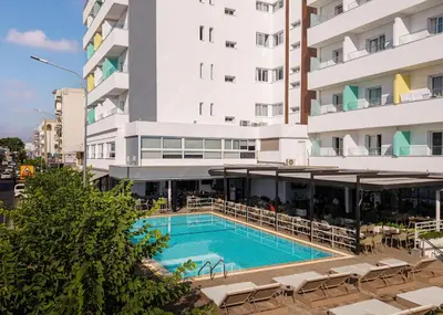 a hotel with a swimming pool in front of a building at Pefkos City Hotel in Limassol