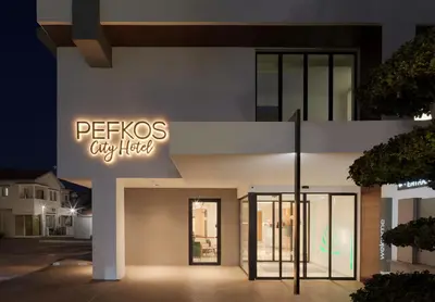 a building with a sign that reads petsos cyberfield at Pefkos City Hotel in Limassol