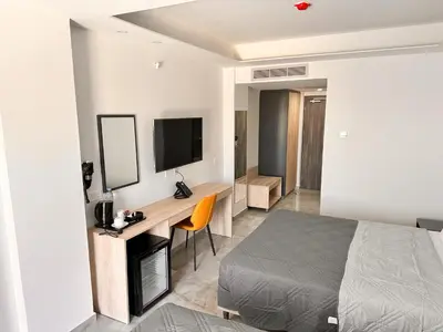 a bedroom with a bed and a desk and a television at Papouis Protaras Hotel in Protaras