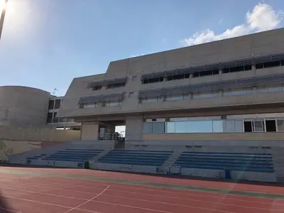 a building with blue seats in front of a stadium at Allegra GSP Sport Center in Nicosia
