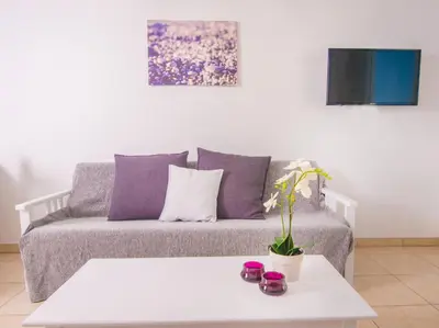 a living room with a couch with purple pillows at Alva Hotel Apartments in Protaras
