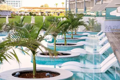 a row of palm trees in a pool at a resort at Asterias Beach Hotel in Ayia Napa