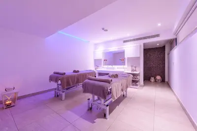 a white room with two beds and a sink at Asterias Beach Hotel in Ayia Napa