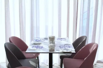 a table with pink chairs and a table with a tableablish at Kapetanios Bay Hotel Protaras in Protaras