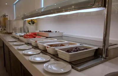 a row of dishes on a counter in a kitchen at Kapetanios Bay Hotel Protaras in Protaras