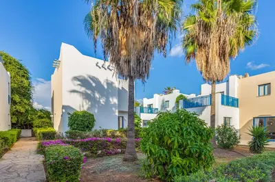 a building with palm trees in front of it at MarisMare Apartments in Ayia Napa