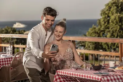 a man and a woman looking at a cell phone at Capo Bay Hotel in Protaras
