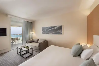 a hotel room with a bed and a couch at Capo Bay Hotel in Protaras