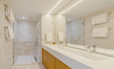 a bathroom with two sinks and a shower at Golden Bay Beach Hotel in Larnaka