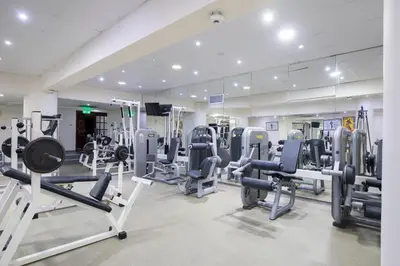 a gym with tread machines and a mirror at Golden Bay Beach Hotel in Larnaka