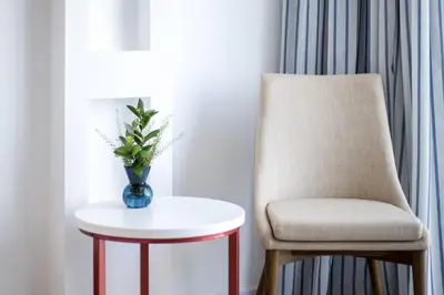 a chair and a table with a vase on it at Lordos Beach Hotel & Spa in Larnaka