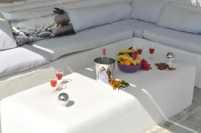 a table with a bowl of fruit and glasses of wine at Katikies 22 in Pissouri