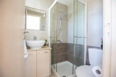 a bathroom with a shower and a toilet and a sink at George's Lux Villa in Protaras