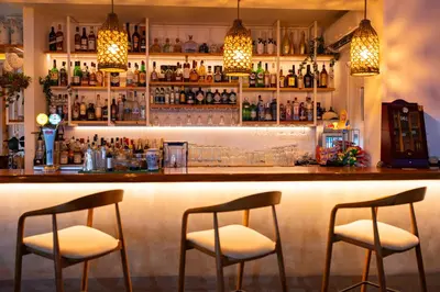 a bar with two chairs and a counter with bottles at Blue Harbour Boutique in Ayia Napa