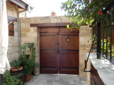 a wooden garage door on a stone wall at Niki's House in Limassol