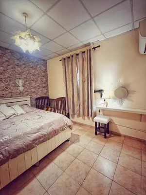 a bedroom with a bed and a table and a mirror at Mamas Summer House in Larnaka