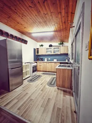 a large kitchen with wooden floors and a wooden ceiling at Mamas Summer House in Larnaka
