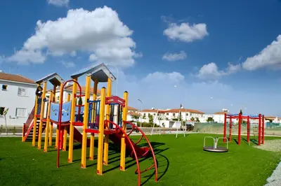 a row of playground equipment on a green field at Sunny Cyprus in Paralimni