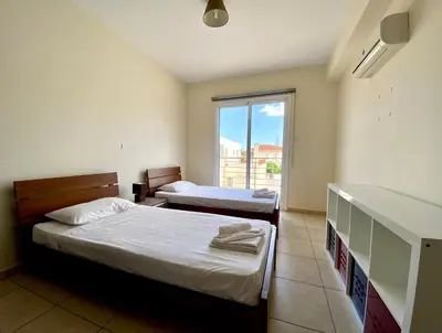 a hotel room with two beds and a window at Sunny Cyprus in Paralimni