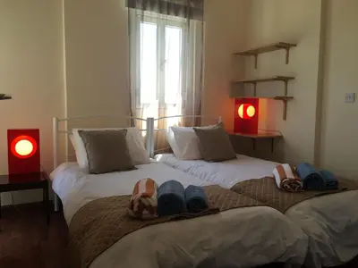 two beds with flip flops on them in a bedroom at Alex Beach Apartment 51 in Larnaka