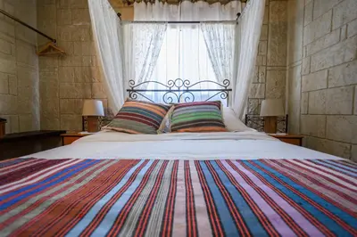a bedroom with a large bed with a colorful blanket at Vasiliou House in Khandria