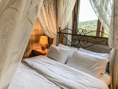a bedroom with a bed with white sheets and a window at Vasiliou House in Khandria
