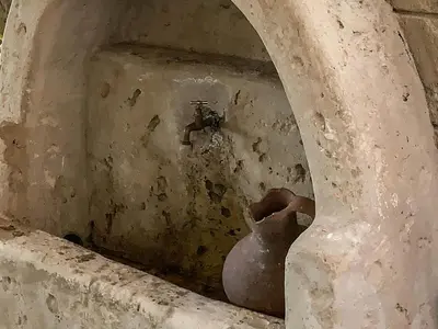 a vase sitting next to a wall with a water fountain at Vasiliou House in Khandria