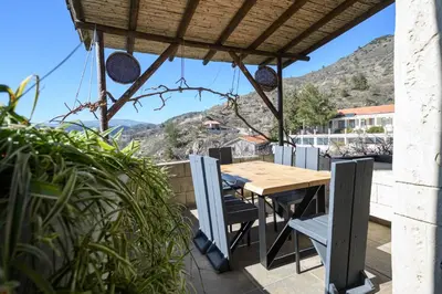 a wooden table and chairs on the balcony of a house at Vasiliou House in Khandria