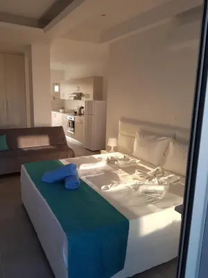 a bedroom with a large bed with a blue towel on it at Christopher's Sandy Beach Suites in Ayia Napa