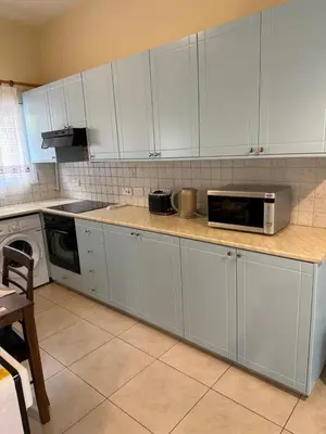a kitchen with white cabinets and a microwave at Vergi Apartments in Pyla