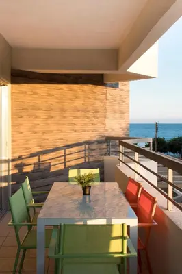 a table and chairs on a balcony with the ocean at Eden Beach Apartment 207 in Limassol