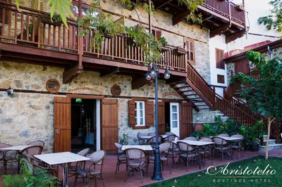 a patio with tables and chairs in front of a building at Aristotelio Boutique Hotel in Pedoulas