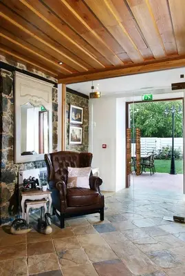 a living room with a leather couch and a table at Aristotelio Boutique Hotel in Pedoulas