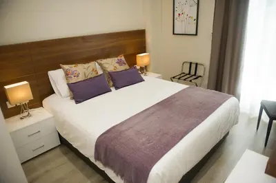 a bedroom with a large bed with purple pillows at Manolia City Residences in Nicosia