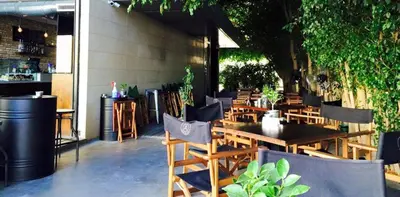 a restaurant with wooden tables and chairs and plants at Manolia City Residences in Nicosia