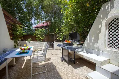 a patio with a grill and a table and chairs at Protaras Central Sunrise in Protaras