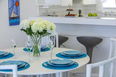 a white table with blue plates and flowers on it at Protaras Central Sunrise in Protaras