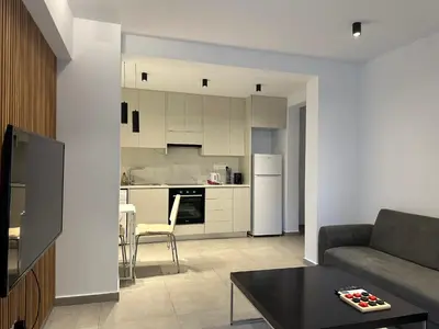 a living room with a couch and a kitchen at Royal Sunset Studios & Apartments in Limassol