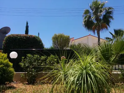 a garden with palm trees and plants in front of a building at Royal Sunset Studios & Apartments in Limassol