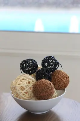a white bowl filled with balls of yarn on a table at SeaBreeze Villas by TrulyCyprus in Ayia Napa