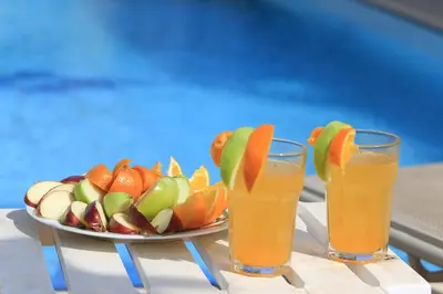 a plate of fruit and two glasses of orange juice at SeaBreeze Villas by TrulyCyprus in Ayia Napa