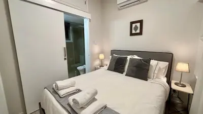 a bedroom with a bed with white sheets and pillows at SeaBreeze City Center Flats by TrulyCyprus in Limassol