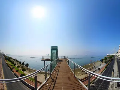 a walkway over a beach with the ocean in the background at SeaBreeze City Center Flats by TrulyCyprus in Limassol
