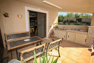 a patio with two benches and a table and a kitchen at Villa Vasa in Vasa Kilaniou