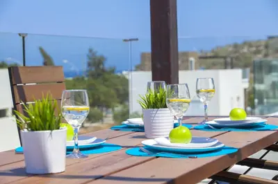 a wooden table with glasses of wine on it at Protaras Villa Anemoni 6 in Protaras