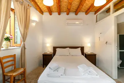 a bedroom with a bed with two chairs and two lamps at Annis House in Kato Lefkara