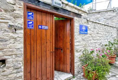 a wooden door in a stone building with signs on it at Annis House in Kato Lefkara