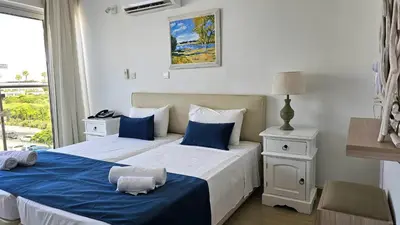 a bedroom with two beds with blue and white at NissiLant hotel & suites in Ayia Napa