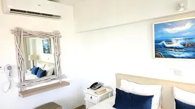 a bedroom with a mirror and a bed at NissiLant hotel & suites in Ayia Napa